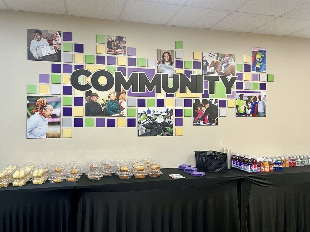 Refreshment tables beneath a community photo display at Buffalo Federation of Neighborhood Centers.