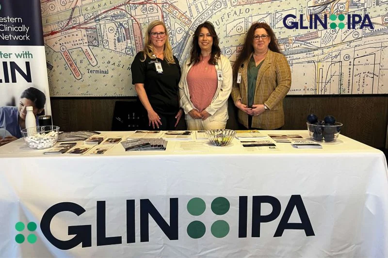 Three representatives stand behind the Great Lakes Integrated Network display table.