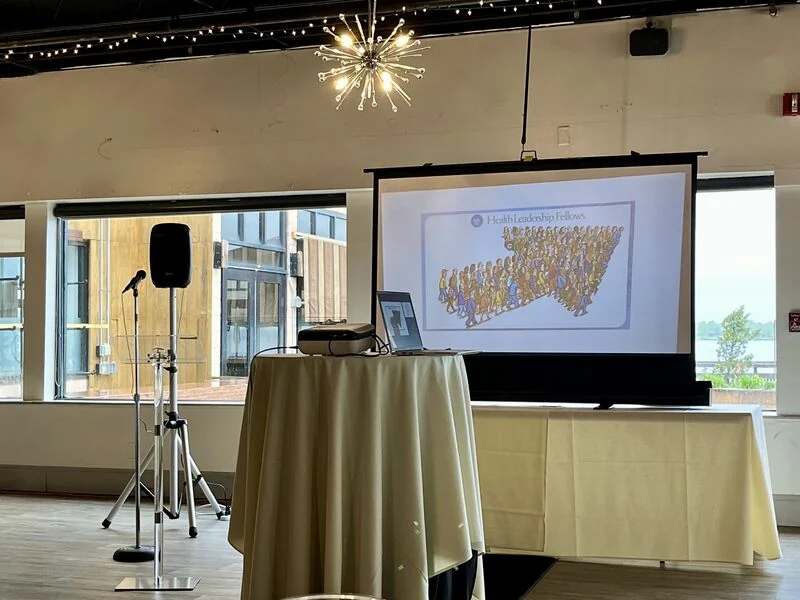 A microphone and presentation screen set up for a community meeting.