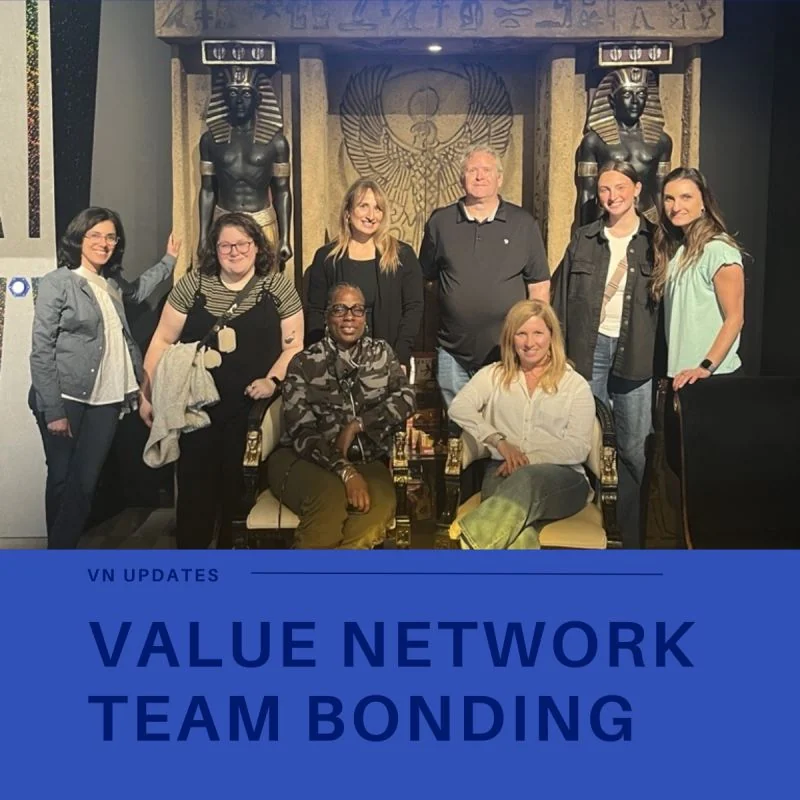 The Value Network team poses in an Egyptian-themed escape room above a team-bonding caption.