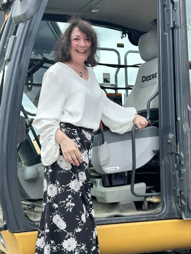 An attendee stands at the cab of construction equipment during Endeavor’s groundbreaking.