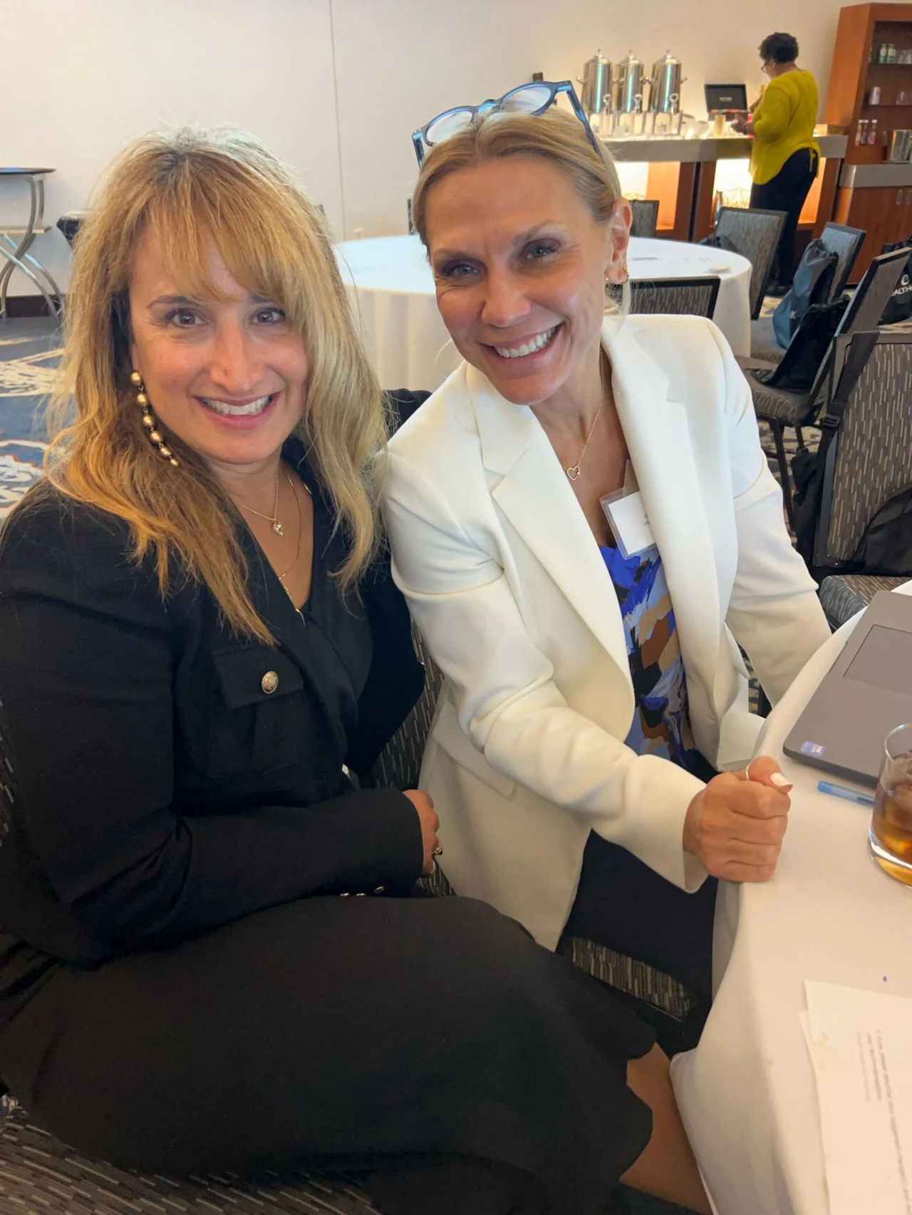 Two forum attendees pose together at a table.